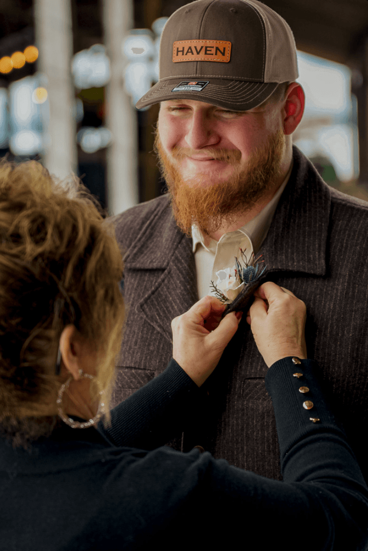 Authentic photo of groom getting flower pinned on his shirt
